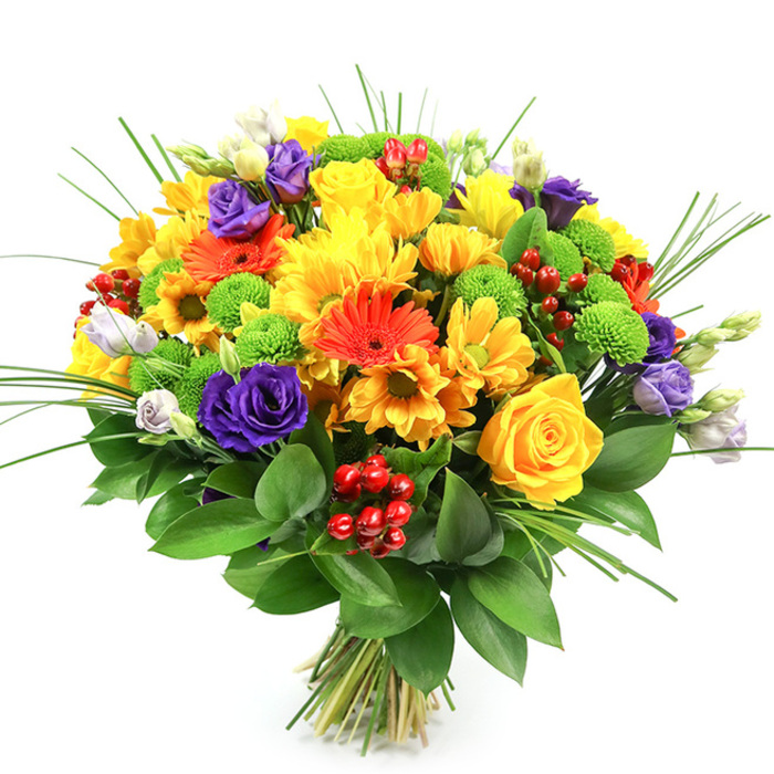 Photographed against a clean white background, this hand-tied bouquet showcases a full, rounded profile and a palette that dances between warm and cool tones, much like a lively afternoon around Brent Cross Shopping Centre. At the forefront are radiant yellows: generous roses with neat, spiralling petals nestle among plush chrysanthemums and smaller daisy-style blooms, all in hues that suggest sunshine spilling across a windowsill. These are joined by glowing orange gerbera daisies, their broad, flat petals and distinct, darker centres forming strong focal points that draw the eye. Interspersed among them are additional orange-toned flowers, helping to shape a continuous ribbon of warmth that flows around the bouquet. To balance the heat, luxurious purple lisianthus blooms add depth; their layered petals twist and curl softly, reminiscent of silk ribbons, accompanied by a handful of buds in lavender and white that lend a feeling of delicacy and growth. Scattered throughout the design, lime-green button chrysanthemums introduce playful, rounded textures, their crisp green tones bridging the gap between the warm oranges and cool purples. Nestled between petals and leaves, glossy red hypericum berries form compact clusters, shining like tiny ornaments and contributing to a sense of celebration and festivity. Slender, upright blades of ornamental grass emerge gracefully from the centre, providing height and movement, while a deep collar of dark green foliage at the base frames the entire arrangement, enhancing its sculpted, dome-like shape. The stems, visible below, are tightly bound, ready to be placed in a favourite vase on a dining table near Hendon Central or delivered as a thoughtful gesture to friends and family across Brent Cross. The bouquet exudes happiness, gratitude, and an easy elegance that suits birthdays, congratulations, or simple moments of appreciation.