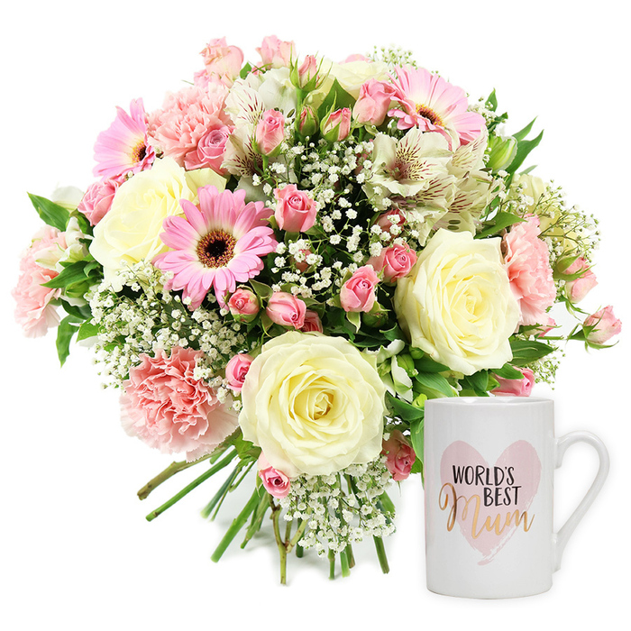 This studio photograph, shot against a clean white backdrop, showcases a beautifully coordinated Mother's Day gift set that would be right at home on a dining table in Brent Cross. On the left, a rounded, hand-tied bouquet is composed in a gentle, romantic palette of creams, blush pinks, and lively bright pinks, accented with fresh greens. Several large cream-coloured roses anchor the arrangement, their petals unfolding in tight spirals that suggest both luxury and tenderness. Circling them are soft pink carnations with delicately fringed edges, creating layers of texture and depth. Bright pink gerbera daisies with deep brown centres add a playful, upbeat character, their broad petals radiating like small suns and drawing the eye immediately. Scattered amid these larger blooms are smaller pink spray roses, some fully open, others still budding, adding a sense of movement and growth, as though the bouquet has its own quiet story. Wisps of white gypsophila float delicately between the flowers, softening their outlines and giving the whole arrangement an airy, cloud-like quality. Slender white alstroemeria stems threaded through the bouquet display narrow petals streaked with fine reddish-brown markings, lending a refined, almost painterly touch. Fresh green foliage peeks from beneath and around the blossoms, framing the pastel tones and bringing to mind gardens and green corners tucked behind homes around Brent Cross and Hendon. The stems are neatly gathered at the bottom, suggesting the bouquet is ready for presentation or delivery. To the right, a pristine white ceramic mug stands upright, gleaming softly. Its design features a blush watercolor heart framing the text World's Best Mum, with the word Mum rendered in a shimmering metallic gold script and World's Best in a darker, contrasting font. Together, the bouquet and mug form a warm, sentimental pairing, ideal for celebrating Mother's Day, marking a special birthday, or sending a heartfelt thank you to a beloved mum in Brent Cross.