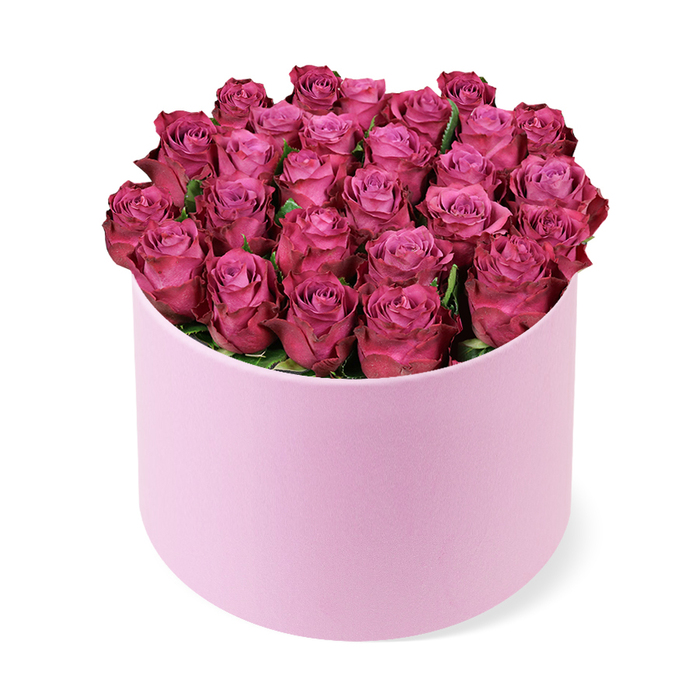 Luxurious and vibrant, this bouquet of dozens of tightly packed roses in deep fuchsia sits proudly in an elegant light pink hat box. The roses form a dense, domed crown that fills the cylindrical container, their petals showing a tight spiral from budding to early bloom, with rare hints of green foliage peeking through between heads. The soft pink of the box provides a luminous backdrop that makes the magenta tones glow with jewel-like intensity. The box remains upright on a white plane, its velvet-like texture catching the light and lending a subtle sheen to the whole arrangement. The photograph's elevated angle invites a sense of ceremony, as if the bouquet had just been handed to you at a doorstep near Brent Cross's local markets, or delivered to a stylish living room along Cricklewood Lane. Crafted with the same care a master florist would give to a luxury gift, this piece conjures romance, celebration, and refined living, perfect for Valentine's or an anniversary, or for brightening a home with a sophisticated splash of colour. Brent Cross customers can expect reliable, same-day delivery across the area, ensuring this beautiful bouquet arrives fresh and ready to delight.