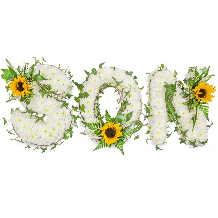 A strong three-dimensional memorial piece reads clearly as the word SON, each capital letter sculpted from a compact mass of pure white chrysanthemums so dense they form a seamless, cloud-like surface. The chrysanthemums' petals overlap in layers that create a soft, cushiony visual field; under studio lighting the subtle shadows between florets give the letters gentle contour. Winding through each letter are long, dark green ivy stems whose five-lobed leaves and curling runners introduce an evergreen note of longevity and connection. Complementary fern fronds and pointed foliage are interspersed to frame the letters and to add tonal variation within the green palette. Three bold sunflowers, their broad golden-yellow petals radiating around deep, textured brown centres, serve as focal anchors: a prominent sunflower is tucked into the upper-left curl of the S, another is placed low in the O to interrupt its circular plane, and a third crowns the upper-right shoulder of the N. The juxtaposition of pristine white blooms, rich greens, and the sunflowers' warm gold speaks to both mourning and a quiet celebration of life. The entire composition is photographed against a stark white background to ensure the tactile density and colour contrasts remain the visual focus. As a bespoke funeral arrangement suitable for services, graveside tributes, or a remembrance display, this design conveys careful craftsmanship and compassionate intent-an understated, personal offering to honour a beloved son in a way that feels both reverent and gently hopeful.
