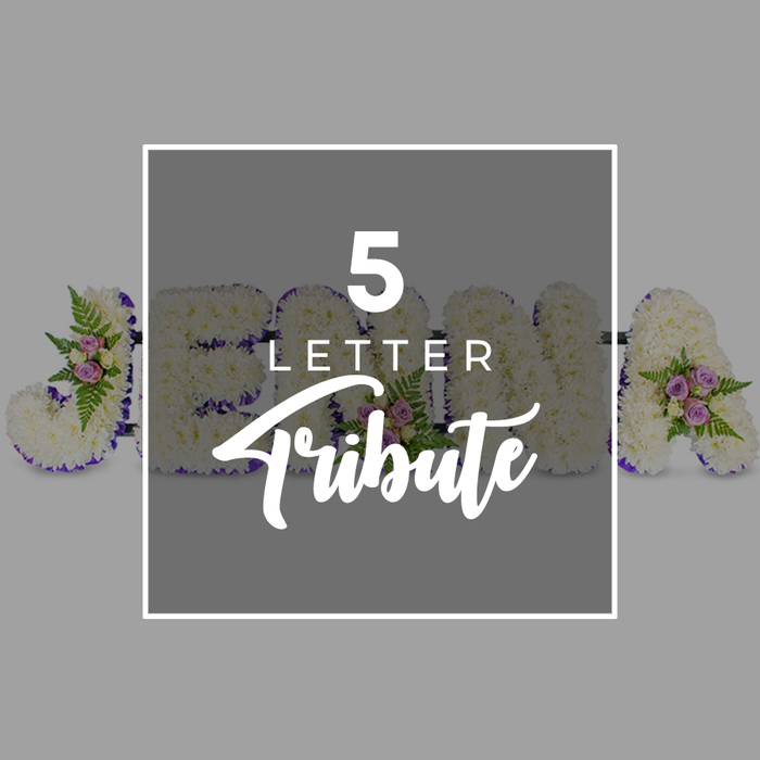 The photograph captures a bespoke five-letter funeral flower tribute arranged in a graceful horizontal line, evoking the quiet atmosphere of a remembrance service near Brent Cross. Each letter is substantial in size and completely carpeted in white chrysanthemums, their compact, many-layered petals overlapping so tightly that they create an uninterrupted, cushion-like effect. The flowers appear freshly arranged, with a slight natural variation in tone that adds life to the overall snowy white surface. Around the outer edge of every letter, a narrow band of deep purple satin ribbon is carefully applied, following each curve and angle. The ribbon's rich colour and gentle sheen provide a refined contrast to the softness of the blooms and help the letters stand out clearly against the soft grey background, much as they would when placed against the draped fabrics of a chapel. At intervals across the tribute, the eye is drawn to small accent sprays: delicate pale pink and mauve spray roses, with some buds pointing upward and other blooms opening to reveal their layered petals, are interwoven with lush green fern fronds and fine foliage. These little clusters lend a romantic, tender feel and introduce hints of gentle fragrance you can almost imagine in the still air. The visible characters suggest a personal name in progress-J on the far left, then O, H, and N partly hidden beneath a central overlay, and an A at the far right-illustrating the custom nature of the design, ideal for any five-letter name or word. Positioned centrally is a semi-transparent grey square with a clean white border. Across it, the words 5 LETTER appear in a straightforward white sans-serif font, stacked above the more decorative script of Tribute, like an elegant label in an online catalogue. The overall impression is one of lovingly executed craftsmanship, calm dignity, and personalised remembrance, the kind of tribute a family in Brent Cross might choose to express their final farewell.