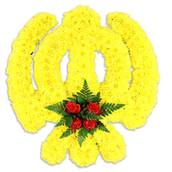 This Khanda-shaped floral tribute is a study in texture and respectful symbolism, formed from a vast field of small, bright yellow chrysanthemum blooms that trace the emblem's circular chakram, the central double-edged khanda and the two crossed kirpans with exacting care. The chrysanthemums are so densely arranged that their ruffled petals create a plush, three-dimensional surface, catching soft light to reveal subtle shadows and highlights across each arc. Anchoring the composition is a compact bouquet of five deep red roses nestled at the centre, their velvety petals surrounded by layers of dark green fern leaves which frame the roses like a quiet crown. Set against a clean white background with a delicate shadow beneath, the piece reads as both a ceremonial board and a standalone memorial wreath - a design often chosen for religious services, remembrance events or community commemorations. The flowers' aromas are understated: the chrysanthemum's faint honeyed sweetness, the roses' richer, classic scent and the green, slightly peppery freshness of the ferns. As florists serving Brent Cross and neighbouring Hendon and West Hendon, Brent Cross Flowers crafts pieces like this with sensitivity to Sikh traditions, often delivering to local gurdwaras or private memorials; the arrangement balances bold colour with solemn dignity, a floral expression of honour, memory and cultural respect.