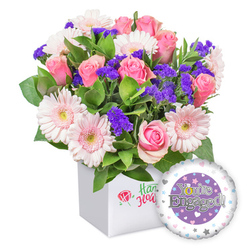 This lush, joyful bouquet radiates warmth and optimism, captured in a crisp, modern white box ready for delivery across Brent Cross and the surrounding NW London neighborhoods. The star players are pink roses, their petals unfurling in soft, creamy spirals that evoke timeless romance, paired with moonlit gerberas in pale blush tones that lend an airy, celebratory lightness. Interspersed among the blooms are clusters of deep purple statice, small but striking, like little pockets of evening color that spark the eye. A generous backbone of fresh green foliage weaves through the arrangement, creating a natural, garden-inspired texture and depth. The presentation box remains minimal and elegant, allowing the flowers' beauty to take center stage, while a discreet front-facing emblem hints at the brand's care without overpowering the display. Beside the bouquet sits a round foil balloon, styled for engagement with a central purple circle bearing the silver inscription "You're Engaged!" and a golden ring motif that subtly elevates the moment. The outer rim of the balloon is white, decorated with pastel hearts and silver stars that shimmer in softer light. This piece, crafted for a joyful milestone, is ideal for same-day or next-day delivery across Brent Cross, Hendon, Cricklewood, and Golders Green, a bright expression of happiness and hopeful beginnings for the couple's shared journey.