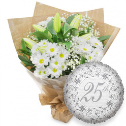 Against a pristine white background, a sophisticated white flower bouquet and a silver "25th" anniversary balloon form a picture of quiet celebration, the sort of arrangement a Brent Cross couple might receive to mark a quarter-century of marriage. The bouquet is rounded and full, brimming with white chrysanthemum daisies whose petals fan neatly around their sunlit yellow centres, creating a cheerful yet gentle radiance. Emerging gracefully from between the daisies, several long white lily buds stand tall, their forms slender and statuesque. The buds remain tightly closed, tipped with a whisper of pale green, hinting at blooms still to come and the unfolding of future days together. Delicate strands of baby's breath slip through the arrangement, tiny white blossoms adding a soft haze that lightens the overall design. Rich, dark green foliage cradles the flowers, framing the snow-white petals and giving structure and depth. The stems are protected in clear cellophane, then wrapped in rustic brown kraft paper whose natural, tactile surface feels like something picked up from a favourite florist near Brent Cross Shopping Centre, carried home through familiar streets. The bottom of the bouquet is neatly gathered and tied, emphasising its hand-tied character. To the lower right of the flowers, a metallic silver foil balloon adds a celebratory sparkle. Its round surface is slightly rippled, catching the light in gentle highlights. Intricate scrolls and floral flourishes circle the edge, while the centre features a prominent "25th" in elegant script. Behind this, the words "Happy Anniversary" repeat softly in subtle grey, reinforcing the theme without overwhelming the eye. Together, the fresh white blooms and the shimmering silver balloon create a timeless tribute to lasting love in NW11.