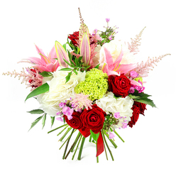 This image showcases an opulent, hand-tied bouquet on a clean white background, its rounded shape densely packed with flowers that feel both generous and refined. At the forefront are velvety deep red roses, their petals curving inward in tight spirals that convey passion and timeless romance. Interlaced with them are large, graceful pink lilies; some are fully open, their broad, silk-like petals spreading wide to display pale centres and prominent stamens, while others appear as smooth, tapered buds, bringing height and the promise of continuing blooms. Cushions of soft white, ruffled flowers sit beneath and between these feature stems, echoing the look of hydrangea or well-petalled carnations and adding a creamy, cloud-soft backdrop. A vibrant ball of lime-green florets, probably Green Trick dianthus, provides a central point of contrast, its fine, tufted texture and fresh colour giving the bouquet a contemporary twist. Wispy, feathery plumes of pale pink astilbe rise above the main body of the flowers, softening the edges and adding airy movement, as if caught by a gentle breeze drifting from the direction of Brent Cross Shopping Centre's open spaces. Tiny accents of fuchsia and lavender blooms are scattered thoughtfully throughout, offering extra bursts of colour that lend the arrangement depth and nuance. Dark green foliage, with a subtle gloss, threads through the bouquet, grounding the brighter tones and enhancing the sense of lushness. The stems are neatly aligned and bound at the base with a single red satin ribbon, emphasising the hand-tied craftsmanship. The bouquet radiates joy, affection, and a sense of special occasion, ideal for romantic gestures, birthday surprises, or thank-you gifts delivered across Brent Cross and nearby neighbourhoods.