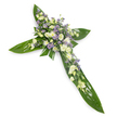 A solemn, meticulously crafted floral cross photographed against a crisp white background from a gentle overhead angle, presenting the tribute with quiet dignity. The cross's structural base is formed of broad, glossy tropical leaves - their deep green surfaces catching a subtle sheen that reveals the strong central veins and smooth, waxy texture that anchor the design. Centered where the vertical and horizontal arms meet, and trailing softly along each arm, is a dense carpet of pale blooms: ruffled white and creamy ivory lisianthus with layered, satin-like petals and elegant buds, interspersed with small, bright white chrysanthemum-like florets that add a clean, luminous texture. Scattered through the clusters are sprays of tiny, star-shaped lavender or light-purple accent flowers - likely limonium or small asters - which introduce a whisper of cool colour and visual depth without disturbing the arrangement's serenity. Fine, delicate green filler foliage weaves among the flowers, softening edges and lending a natural, unforced silhouette against the leaf base. The lighting is even and soft, bathing the composition in a calming, almost spiritual glow that accentuates both the glossy greens and the pale, soothing whites and lavenders. This piece reads as a traditional sympathy arrangement, designed for funerals, memorial services, or church tributes, conveying respect, remembrance, and a quiet hope for peace. It suggests the tactile contrasts of waxy leaves and feather-soft petals, a faint, green-tinged scent of fresh foliage, and an overall atmosphere of contemplative calm - an appropriate image for discussing dignified floral tributes and bereavement etiquette in a local context around Brent Cross and neighbouring Cricklewood or Hendon.