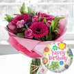 A lavish birthday flower and balloon gift set is displayed in soft natural light, as if ready to be sent from a Brent Cross living room out to a loved one across North West London. At the centre stands a clear glass cylinder vase brimming with fresh blooms in joyful pink tones. Bold fuchsia and magenta gerbera daisies face outward, each with a velvety, near-black centre that draws the eye. Around them, layers of blush and mid-pink roses cluster together, some still in tight, hopeful buds, others gently opening to reveal spiralled petals with a light, romantic fragrance. Tiny stems of deep purple filler flowers thread between the larger heads, giving texture and depth, while generous glossy greenery fans out to frame the arrangement, suggesting a bouquet cut that morning from a local garden. The stems are gathered and wrapped in translucent pastel pink cellophane at the base, the crinkles of the wrapping catching the light and adding a delicate, celebratory halo. A rustic length of twine is tied around the neck of the vase, holding a small off-white swing tag embossed with a subtle rose design, hinting at a premium florist touch familiar to residents near the Brent Cross Shopping Centre and surrounding residential streets. In the foreground to the right, a round, shiny foil balloon floats cheerfully, its white background speckled with pale grey dots and scattered with bright, cartoon-style flowers in yellow, turquoise, lime, and hot pink. Across its centre, the phrase happy birthday is written in bold pink script, mirroring the bouquet's colour palette. The softly blurred interior background lets the flowers and balloon stand out as the clear focus, evoking the warmth of a birthday surprise delivered straight to a doorstep off Hendon Way or near Brent Cross Underground station.