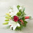 This luxuriously arranged bouquet rests on a pale, textured surface, the handiwork of Brent Cross's skilled floral designers. White lilies shine at the top left-some in full, elegant bloom with their long petals unveiled, others in fresh, lime-hued bud poised with promise. At the very center, a deep red rose unfurls its velvety petals, providing a passionate splash of colour and classic romance. Around the main flowers, green, moss-like florets-perhaps green button chrysanthemums-introduce a unique touch, softening the overall look. Delicate Gypsophila sprigs float throughout, softening the bolder blooms and adding a cloud-like texture reminiscent of the Brent Cross sky in early spring. Lush, deep green foliage forms a generous border, with glossy, sweeping leaves creating contrast and softness. Bright red hypericum berries nestle here and there, their presence festive and lively. Finished with a broad red satin ribbon binding the stems, the bouquet radiates unity and festivity, making it ideal for weddings, anniversaries, or special occasions celebrated in Brent Cross. It is a thoughtful floral creation that speaks of love, elegance, and the gentle artistry characteristic of local florists.