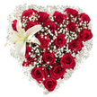 A lovingly sculpted heart of flowers fills the frame: dozens of deep crimson roses packed so closely their velvety petals blend into a luxurious, sculpted mass of red. The roses vary from tight, velvet-green-tipped buds to larger blooms with layered, ruffled petals that catch the light and drop soft, romantic shadows across the heart. Between the red blooms, I've tucked airy clusters of tiny white baby's breath (Gypsophila) so they read like drifting clouds - a feathery halo that softens the intense red and lends a whisper of innocence to the composition. Near the upper left curve a single, stately white lily opens like a quiet punctuation mark; its broad, pristine petals carry a faint cream wash toward the throat and reveal pale yellow stamens that add a touch of warmth against the cool white. The whole arrangement sits against a pure white background, which isolates the colors and makes the reds glow and the whites read as pure light. There's a gentle scent imagined in the composition - the honeyed, green-sweet perfume of roses mingling with the lily's clean, slightly spicy breath - so the piece feels both intimate and ceremonial. Crafted with steady hands, the heart silhouette reads as a deliberate act of affection: suitable for anniversaries, a romantic apology, or a meaningful tribute. As a local florist who knows Brent Cross and neighbouring Cricklewood and Golders Green, I picture this arrangement delivered in soft morning light to a front door on a quiet residential street, where the gesture speaks louder than words and the textures invite a hand to linger.