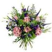 A hand-tied bouquet that feels like a breezy English meadow captured at the height of spring: soft antique-pink roses, some tightly furled, others gently unfurling to reveal slightly darker pink edges, sit at the heart of the arrangement. Two fuller, dusty-rose carnations with ruffled, velvet-like petals add a romantic, tactile weight, while tall, slender spikes of indigo-veronica thrust upward, their deep violet tones giving vertical punctuation and a pleasing contrast. Scattered between these main blooms are clusters of delicate aster-like flowers in pale lavender-blue with sunny yellow centres, lending an airy, wildflower softness. Deep purple lisianthus bloom and bud through the composition, their jewel tones adding depth and moments of quiet drama. The bouquet is cushioned and shaped by a mix of rounded silvery-green eucalyptus leaves and bright lime-green, bushy filler-reminiscent of Santini chrysanthemums-whose crisp texture brightens the palette and supports the blooms. Slender green leaves and small emerging buds peek out, reinforcing the freshly gathered, organic feeling. The stems are gathered and visible at the base, evidence of a gentle hand-tied technique that keeps everything feeling loose and natural. In the soft, diffused light one might see early in Brent Cross near Fryent Country Park, the pastel and jewel tones read both subtle and joyful, and the faint scent suggests green leaves after rain with a whisper of floral sweetness. This bouquet suits quiet celebrations, thank-you gestures, or simply bringing the calm of a local garden into a home by the shopping centre or a nearby terrace in Cricklewood.